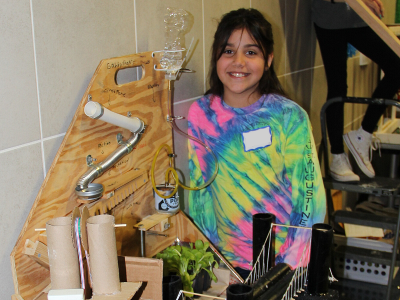 Student smiles behind a science project